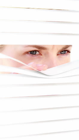 Curious-woman-looking-through-blinds