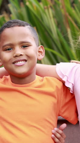 Smiling-pupils-sitting-on-bench