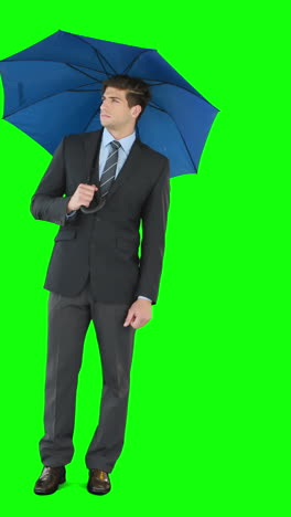 Young-businessman-sheltering-with-umbrella