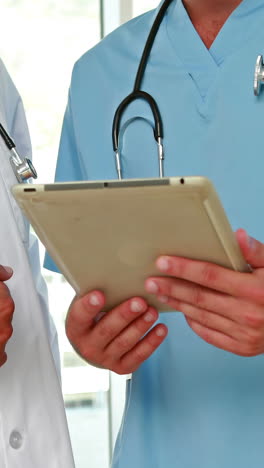 Two-doctors-holding-clipboard-in-medical-office