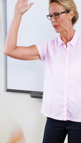 Schoolteacher-and-kids-giving-high-five-in-classroom