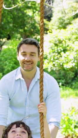 Father-pushing-his-young-son-on-a-swing