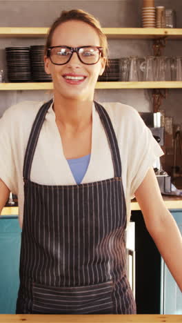 Portrait-of-smiling-waitress-leaning-on-counter