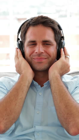 Man-relaxing-on-the-couch-listening-to-music