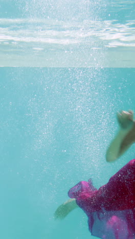 Brunette-in-evening-gown-diving-into-swimming-pool