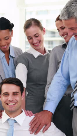 Business-people-smiling-to-their-coworker-on-wheelchair-