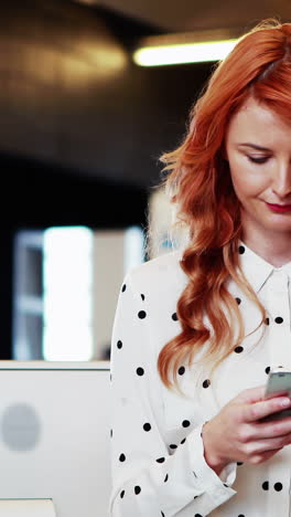 Businesswoman-text-messaging-on-mobile-phone