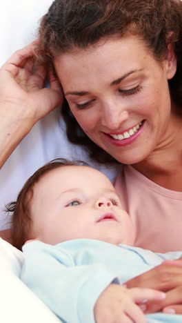 Baby-boy-in-blue-babygro-being-tickled-by-mother