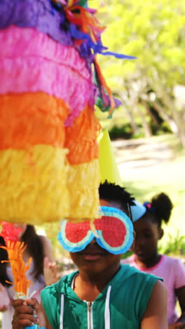 Boy-holding-multicolored-puppet-while-celebrating-birthday-with-friends