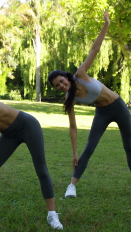 Smiling-fit-friends-stretching-in-the-park