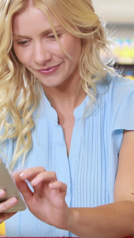 Smiling-blonde-shopping-and-using-smartphone