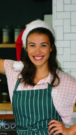 Portrait-of-waitress-and-coworker-standing-with-merry-x-mas-board