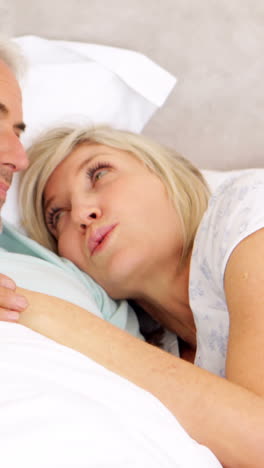 Couple-chatting-in-bed-and-cuddling