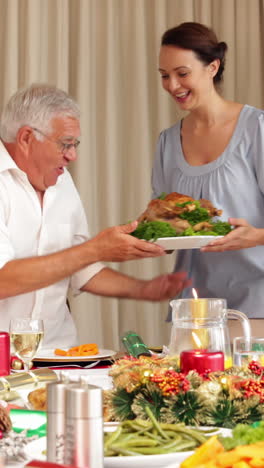 Proud-mother-bringing-roast-turkey-to-the-christmas-dinner-table