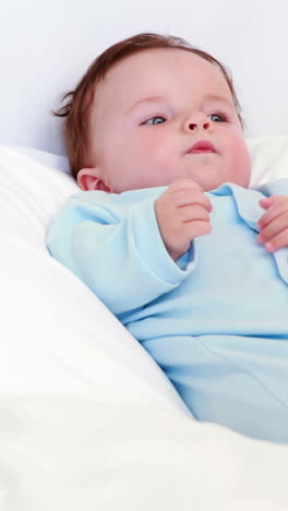 Bebé-En-Babygro-Azul-Acostado-Sobre-Almohadas