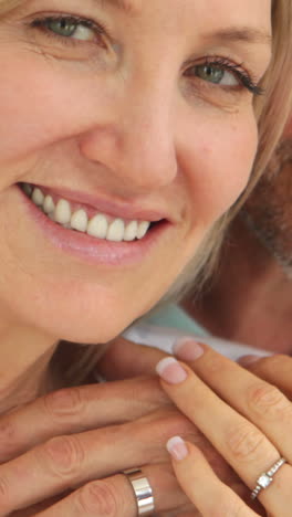 Married-couple-embracing-and-smiling-at-camera-in-bed-together