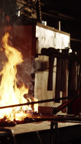 Blacksmith-heating-iron-rod-in-fire