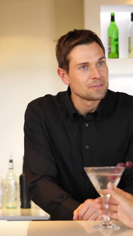 Bartender-serving-a-cocktail-and-chatting-to-customer