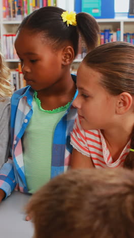 Kids-and-teacher-looking-at-globe-in-library