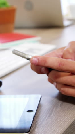 Businessman-using-mobile-phone-at-desk