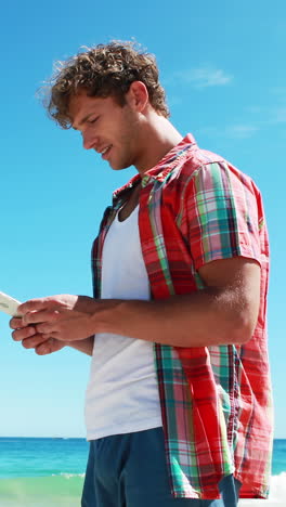 Man-talking-on-mobile-phone-at-beach