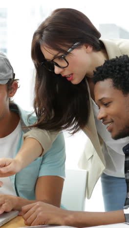 Employees-working-together-on-laptop-at-desk