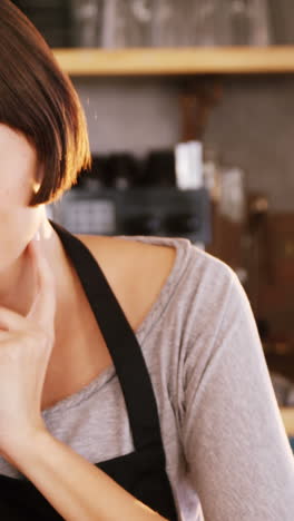 Portrait-of-waitress-sitting-at-dessert-counter