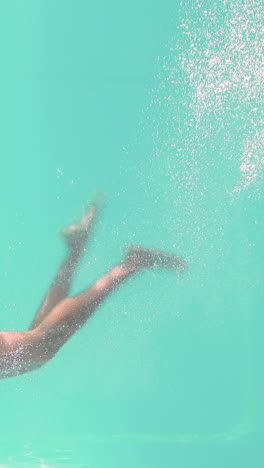 Smiling-woman-swimming-underwater