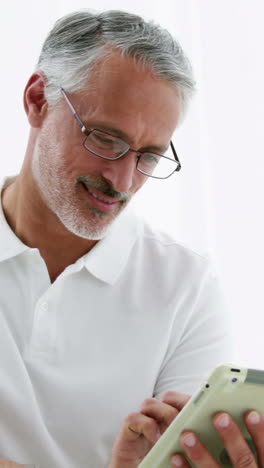 Smiling-man-using-his-tablet