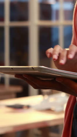 Casual-businesswoman-using-tablet-in-front-of-colleague