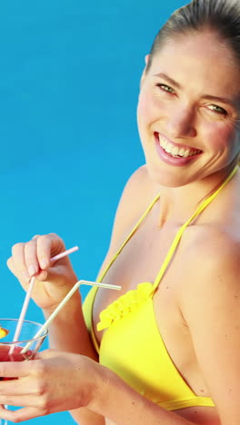 Hermosa-Rubia-En-Bikini-Disfrutando-De-Un-Cóctel-Junto-A-La-Piscina