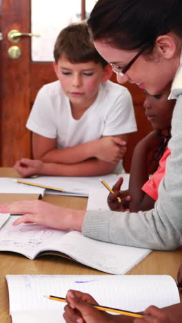 Teacher-helping-her-pupils-during-class