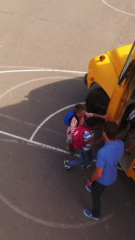 Teacher-giving-high-to-kids-while-entering-in-bus