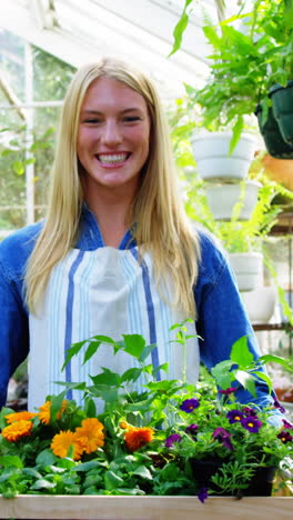 Portrait-of-beautiful-woman-carrying-flower-plant