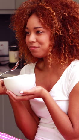 Pretty-woman-smiling-while-eating-her-breakfast