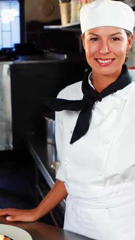 Smiling-chef-standing-at-kitchen-counter