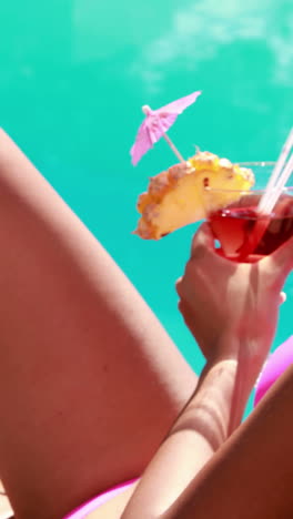 Sexy-Brünette-Sitzt-Auf-Einem-Liegestuhl-Am-Pool-Und-Trinkt-Einen-Cocktail