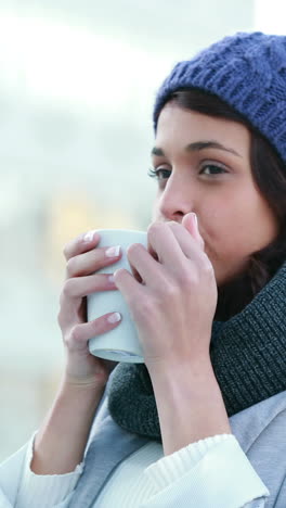 Smiling-woman-drinking-hot-beverage