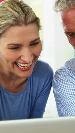 Mature-couple-using-laptop-in-living-room