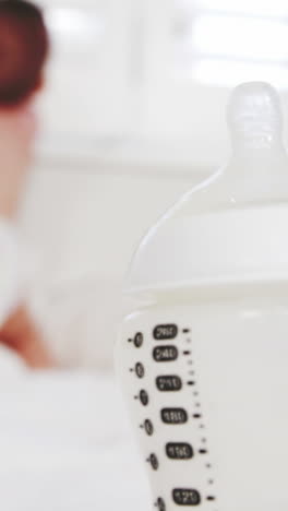 Close-up-on-baby's-bottle-with-the-baby-on-background