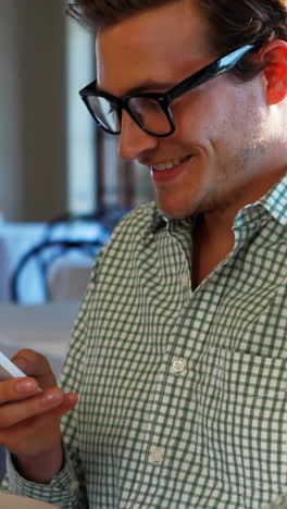 Man-checking-his-mobile-phone-in-the-restaurant