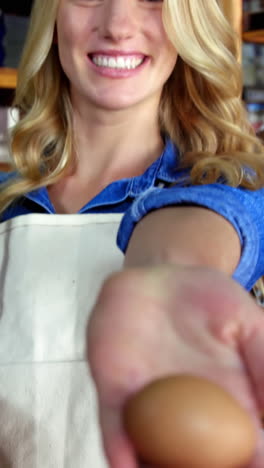 Smiling-female-staff-holding-basket-and-egg-in-super-market