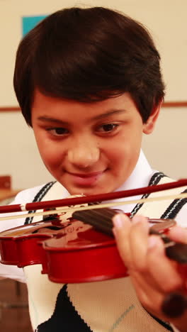 Cute-pupil-playing-violin-in-classroom