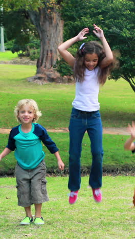 Glückliche-Kinder-Springen-Zusammen-Im-Park