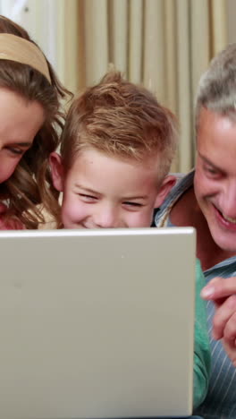 Glückliche-Familie-Mit-Laptop-Auf-Der-Couch