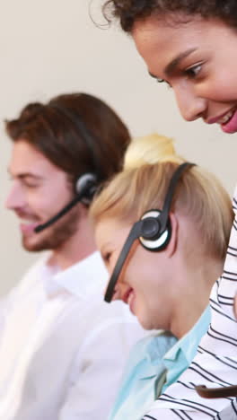 Smiling-businesswoman-briefing-call-center-agent