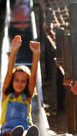 Schoolgirl-sliding-on-slide-in-school-playground