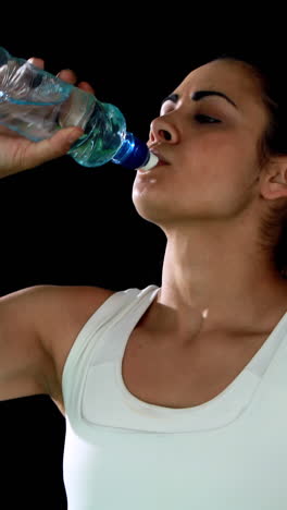 Fit-brunette-catching-her-breath-and-drinking-water