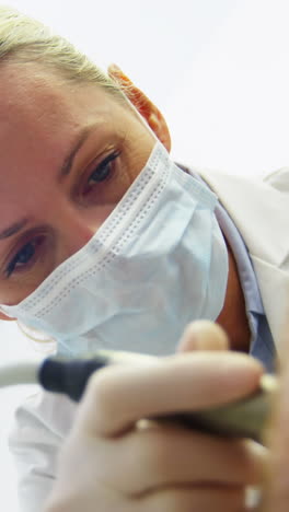 Dentist-examining-a-patient-with-tools