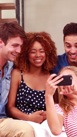 Smiling-friends-taking-selfies-with-smartphone